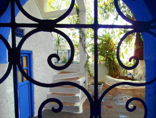 een poort met een blauwe deur en een trap bij Patio De La Luna in Asilah