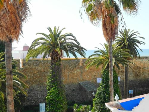 a group of palm trees in front of a wall at Patio De La Luna in Asilah
