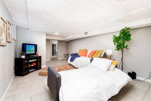 a bedroom with a large bed and a tv at Cozy Family Cottage - Historic Top of The Hill in Tower Grove