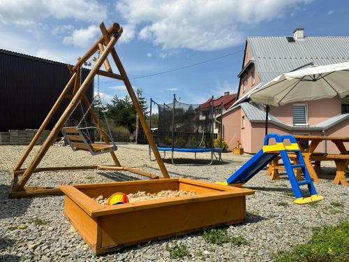 een speeltuin met een schommel en een glijbaan bij Nocowanie w młynie in Niedzica