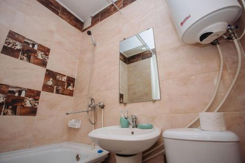 a bathroom with a toilet and a sink and a mirror at 1-комнатная квартира в центре на Аль-Фараби 93 in Kostanay