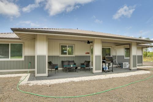 a house with a patio with a green hose at Keaau Getaway with Patio, 3 Mi to Shipman Beach! in Keaau