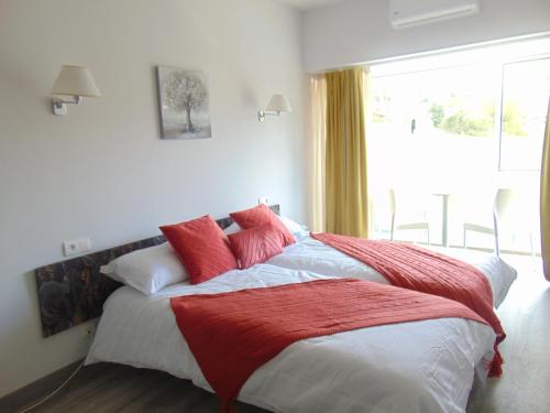 - une chambre dotée d'un grand lit avec des oreillers rouges et blancs dans l'établissement Hotel El Mirador del Nalon, à San Román