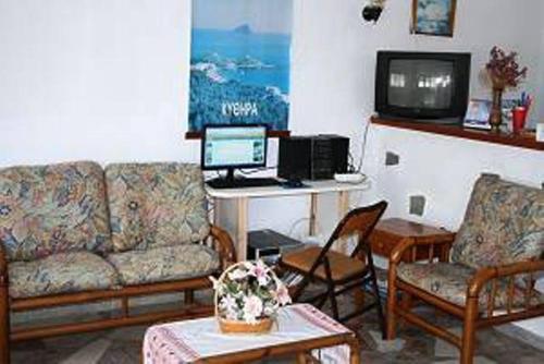 a living room with a couch and a desk with a computer at Hotel Rea in Naxos Chora