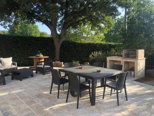 eine Terrasse mit einem Tisch, Stühlen und einem Baum in der Unterkunft Casa Rubino, Canale di Pirro - Valle d'Itria in Selva di Fasano