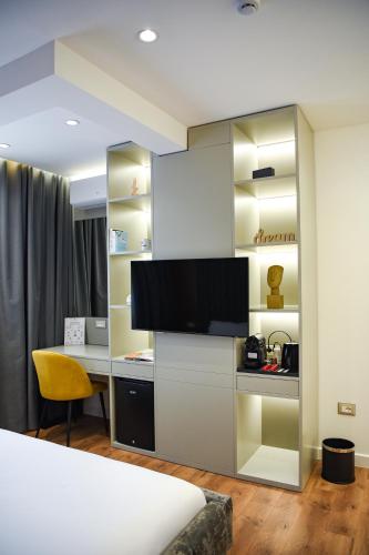 a hotel room with a desk and a tv in a room at The Wilson Tirana in Tirana