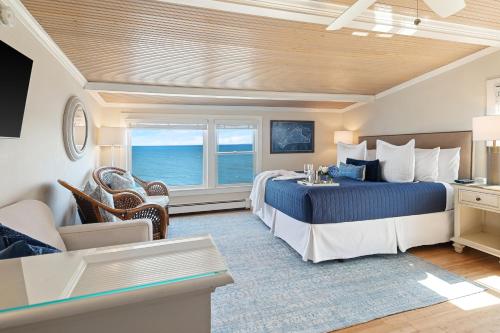 a hotel room with a bed and a view of the ocean at Inn on the Sound in Falmouth
