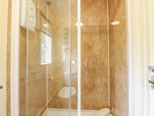 a shower with a glass door in a bathroom at 11 The Dell in Norwich