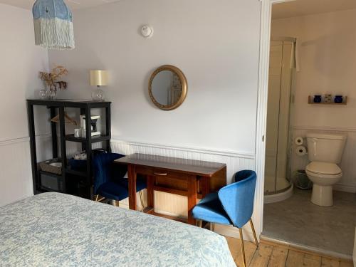 - une chambre avec une table et des chaises bleues ainsi qu'une salle de bains dans l'établissement Maison Charles Edmond, à Grandes-Bergeronnes