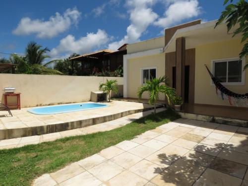 a backyard with a swimming pool and a house at Casa Mar e Dunas in Icaraí