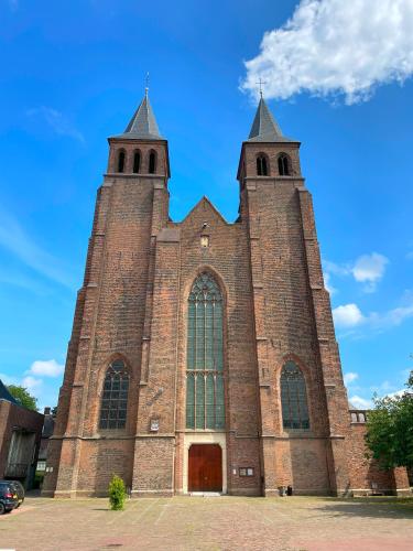 a large brick church with two towers at Walburgis Residenties in Arnhem