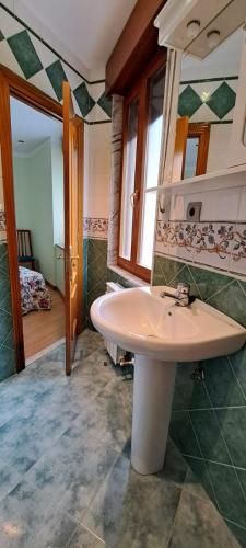 a bathroom with a white sink and a bedroom at Llanes-Llumedian in Llanes
