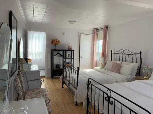 - une chambre avec un lit et une chaise dans l'établissement Maison Charles Edmond, à Grandes-Bergeronnes