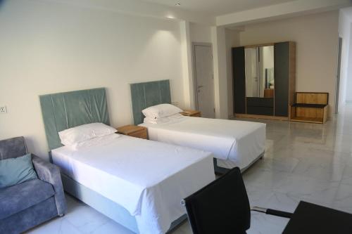 a bedroom with two beds and a chair and a mirror at Areni Lodge in Areni