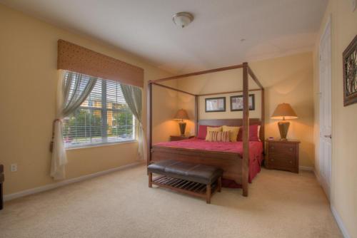 a bedroom with a canopy bed and a window at Palm Villa in Orlando