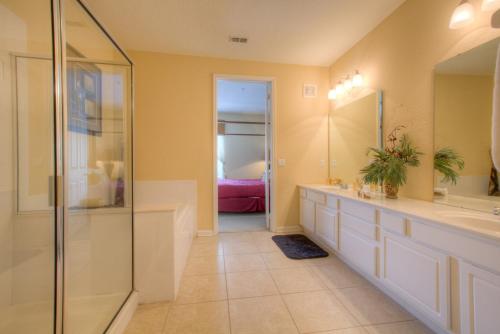 a bathroom with a walk in shower and a sink at Palm Villa in Orlando