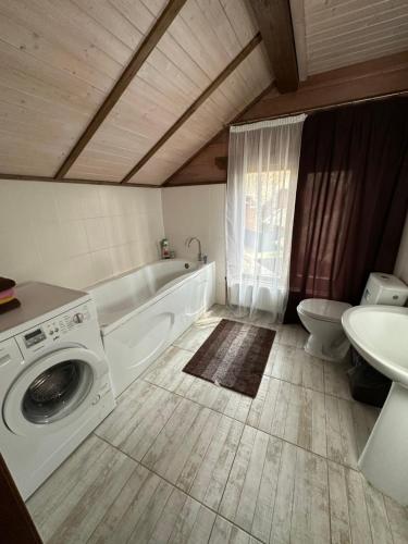 uma casa de banho com uma máquina de lavar roupa e um lavatório em Dacha 6 em Voropayev