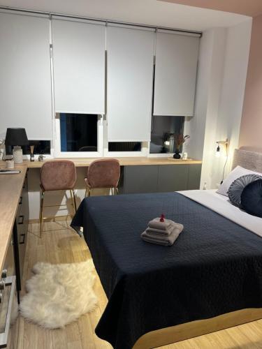 a bedroom with a bed and a kitchen with windows at City Centre Suites in Komotini