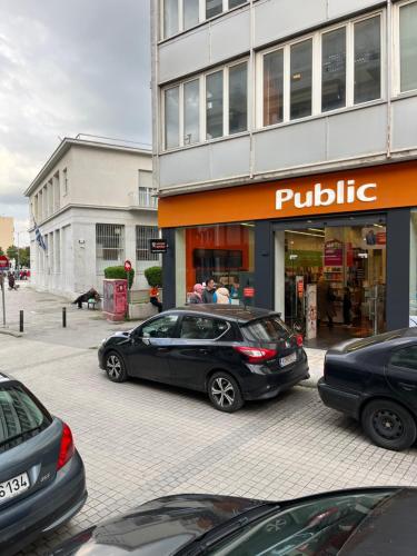 a parking lot with cars parked in front of a building at City Centre Suites in Komotini