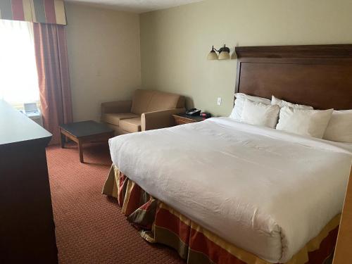 Habitación de hotel con cama y silla en The Boardwalk Inn en Branson