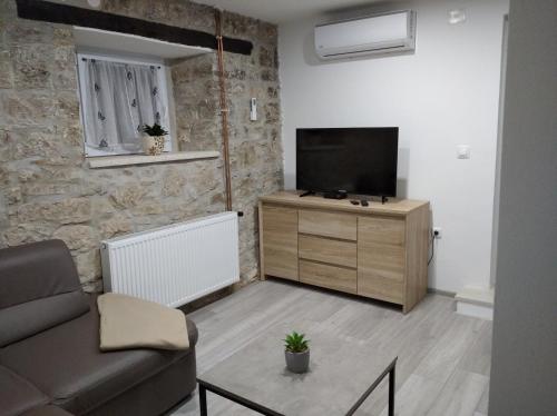 a living room with a couch and a flat screen tv at Apartman Lari in Vižinada