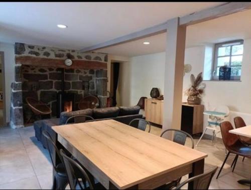 a living room with a wooden table and a couch at Auberge du Pont in Saint-Projet-de-Salers