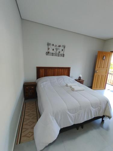 a bedroom with a large white bed in a room at Pouso Casa da Vovó in Tiradentes
