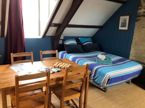 une chambre avec deux lits, une table et des chaises dans l'établissement La Vigie, à Groix