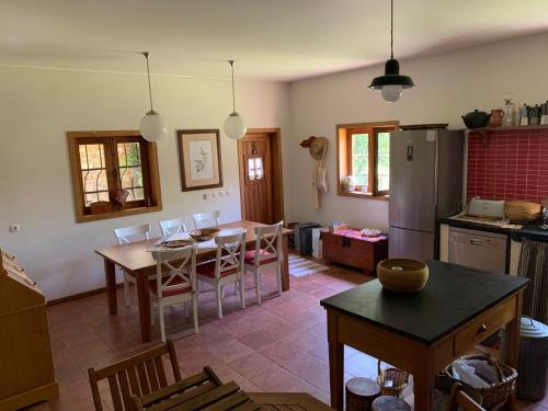 a kitchen and dining room with a table and a refrigerator at Casa da Touça in Celorico de Basto