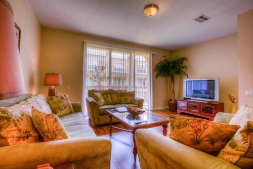 a living room with two couches and a tv at Resort Townhome: Perfect Orlando Vacation Spot in Orlando