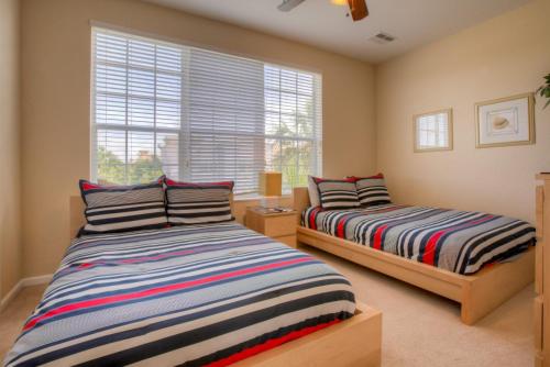 1 dormitorio con 2 camas y ventana en Resort Townhome: Perfect Orlando Vacation Spot en Orlando