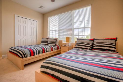 a bedroom with two beds and a window at Resort Townhome: Perfect Orlando Vacation Spot in Orlando