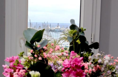 een vaas met bloemen met uitzicht op een haven bij Appartement 5 min des plages Croisette in Cannes