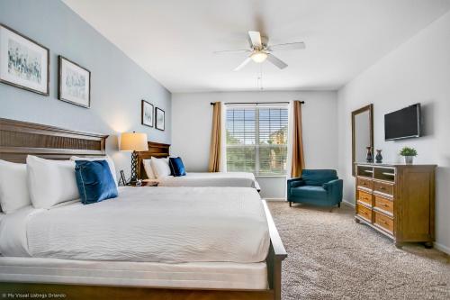 a bedroom with two beds and a blue chair at NY Getaway in Orlando