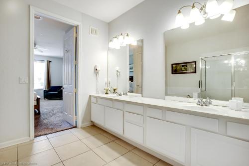 a white bathroom with two sinks and a mirror at NY Getaway in Orlando
