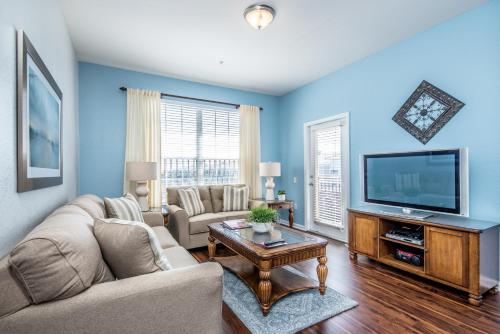 a living room with a couch and a tv at Majestic Holiday in Orlando