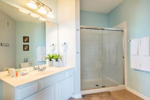 a bathroom with a glass shower and a sink at Majestic Holiday in Orlando