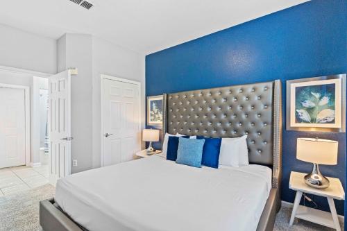 a bedroom with a large bed with a blue wall at Tropical Treasure in Orlando