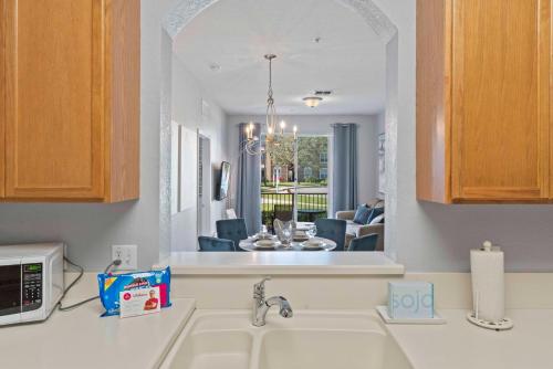 a kitchen with a sink and a view of a living room at Tropical Treasure in Orlando