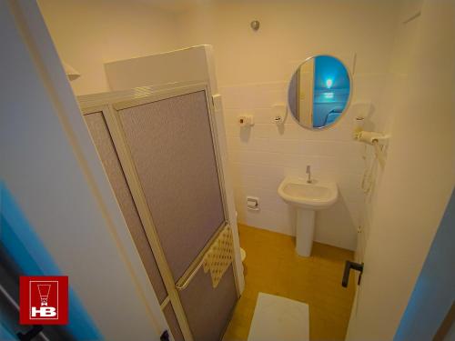 a bathroom with a shower and a sink and a mirror at Hotel Bruggemann in Florianópolis