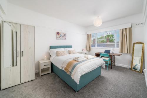 a bedroom with a bed and a desk and a mirror at Bright West Hampstead Retreat in London
