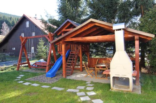 eine Holzspielstruktur mit einer Rutsche und einem Spielplatz in der Unterkunft Apartment Ostružná in Ostružná