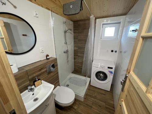 a bathroom with a toilet sink and a washing machine at Domki u Tosiek in Stegna