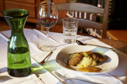 a table with a plate of food and a glass of wine at Biolandhaus Arche in Eberstein