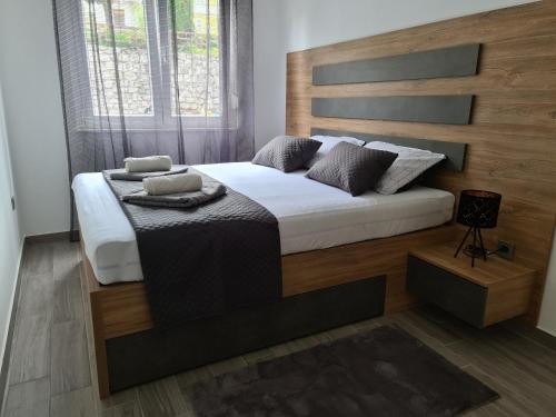 a bedroom with a large bed with a wooden headboard at Apartman Nika in Crikvenica