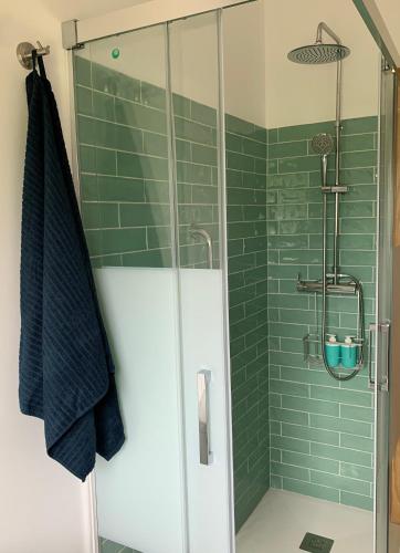 a bathroom with a shower with green tiles at Casa Frutales - Landhaus mit Garten nahe Strand und Finisterre in Fisterra