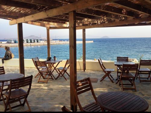 a group of tables and chairs in front of the ocean at Three Brothers in Mandrakion