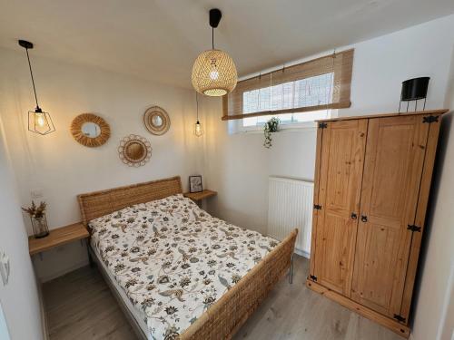 a bedroom with a bed and a wooden cabinet at Apartamenty Kowalska in Kościerzyna