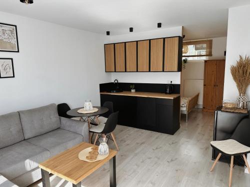 sala de estar con sofá y mesa en Apartamenty Kowalska, en Kościerzyna