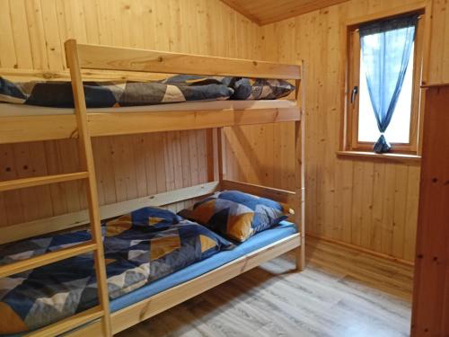 Zimmer mit Etagenbett und 2 Etagenbetten in einer Hütte in der Unterkunft Domek 2 w Rancho Żnin in Żnin